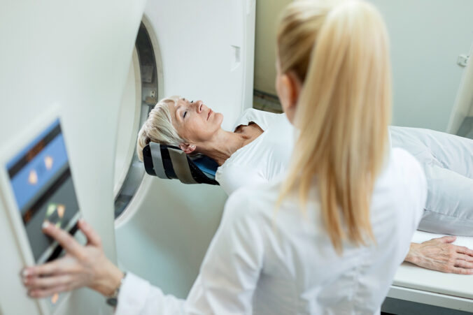 Medizinische Technologin für Radiologie betreut Seniorin beim MRT