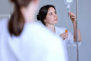 Pflegefachassistentin überprüft eine Infusion.