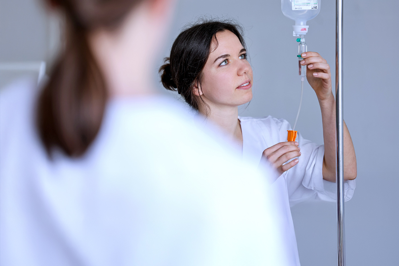 Pflegefachassistentin überprüft eine Infusion.