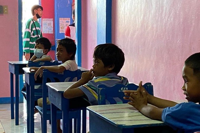 Schulkinder an Pulten bei Kids Island in Manila