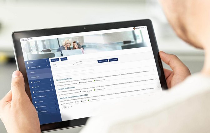 Person betrachtet Seminarangebot online auf dem Tablet