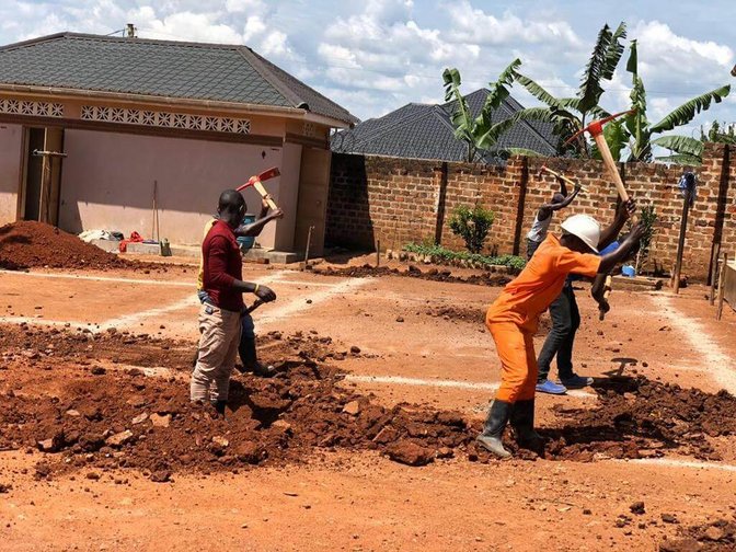 Bauarbeiter beim Ausheben des Fundaments eines Kinderhauses in Uganda