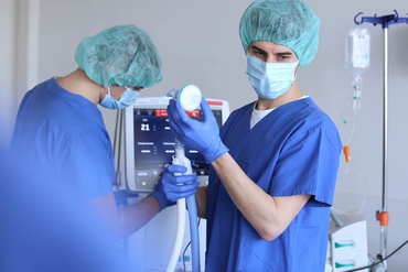 Zwei Intensivkrankenpfleger arbeiten an einem Beatmungsgerät.