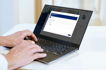 Eine Person sitzt an einem Laptop und arbeitet mit easySoft Publish.